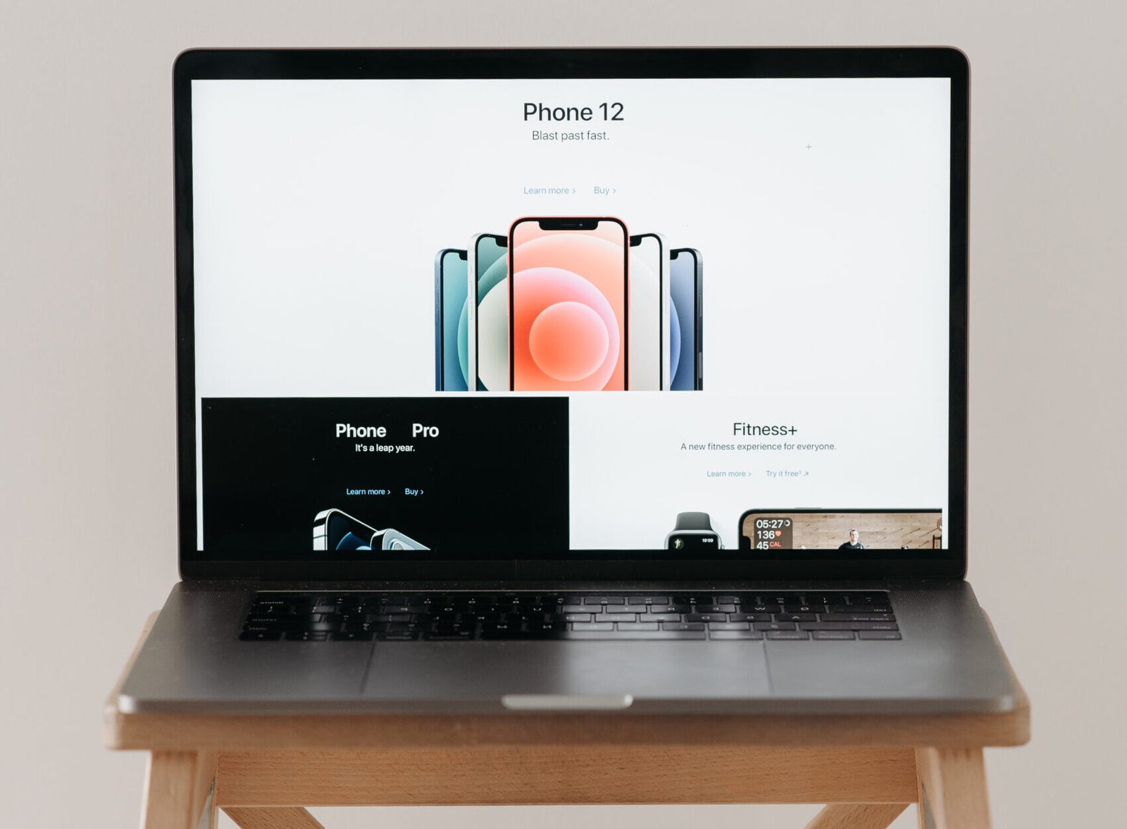 A sleek laptop on a wooden table showing a smartphone advertisement, perfect for tech and gadget content.
